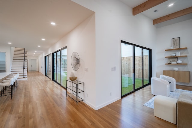 dining space featuring ceiling fan, light hardwood / wood-style floors, beam ceiling, and high vaulted ceiling