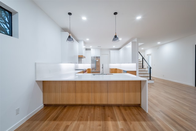 kitchen featuring light hardwood / wood-style flooring, double oven range, lofted ceiling, decorative light fixtures, and custom range hood