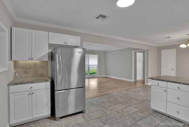 kitchen featuring ornamental molding, white cabinets, stainless steel fridge, light wood-type flooring, and decorative backsplash