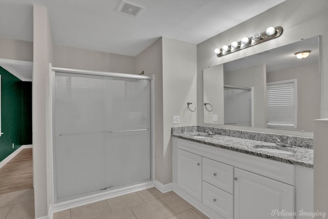 bathroom featuring vanity, a shower with door, and tile patterned flooring