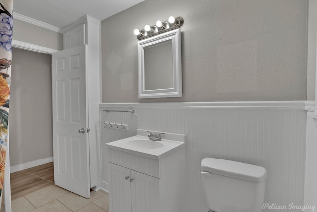 bathroom featuring vanity, tile patterned flooring, toilet, and crown molding