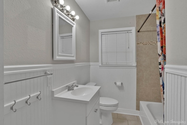 full bathroom with toilet, tiled shower / bath combo, vanity, and tile patterned flooring