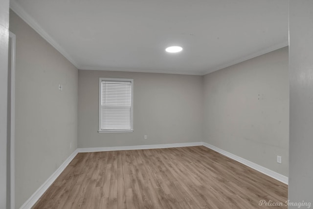 spare room featuring ornamental molding and light hardwood / wood-style flooring