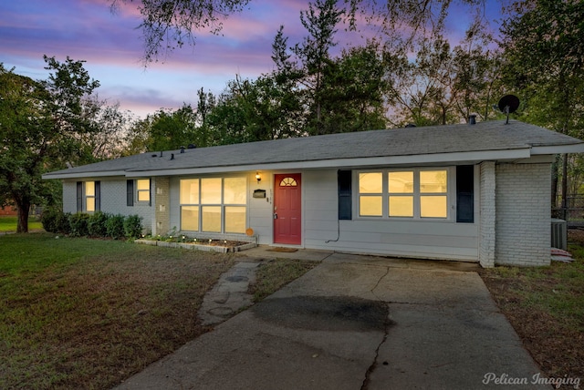 ranch-style house featuring cooling unit and a yard