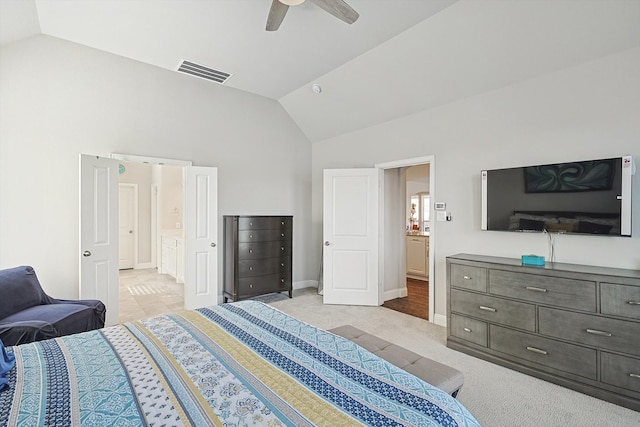 bedroom featuring ceiling fan, ensuite bath, vaulted ceiling, and light colored carpet