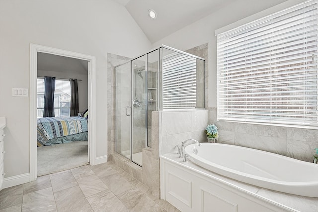 bathroom featuring a wealth of natural light, lofted ceiling, and independent shower and bath