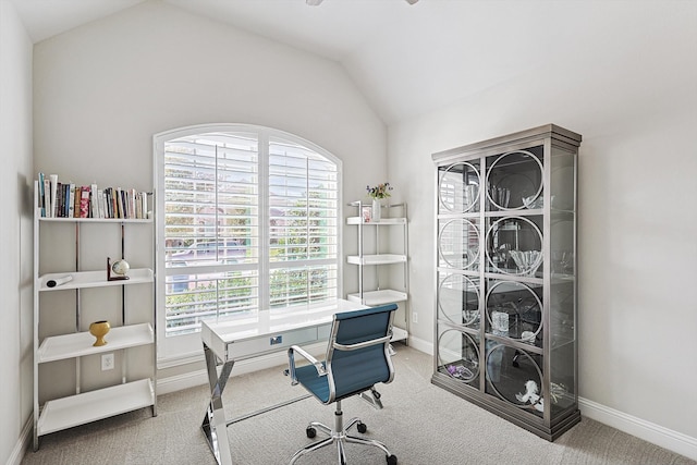 carpeted home office featuring vaulted ceiling