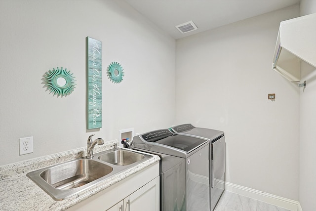 washroom with independent washer and dryer and sink