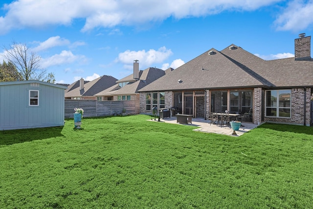 back of house with a patio, a storage unit, and a lawn