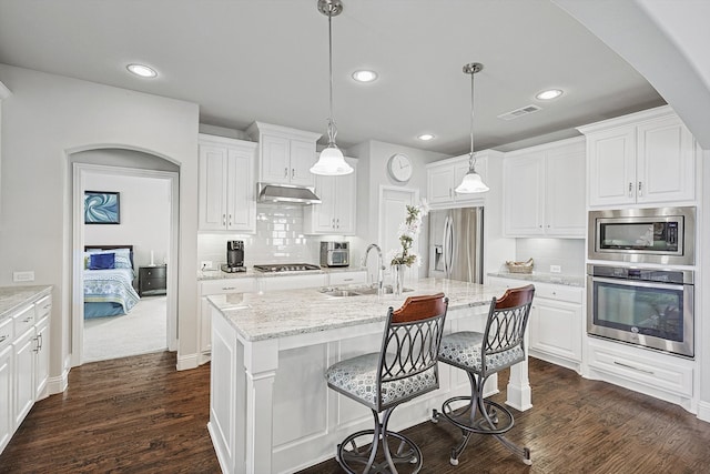 kitchen featuring appliances with stainless steel finishes, white cabinets, sink, and pendant lighting