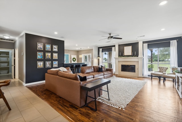 living room featuring ceiling fan, crown molding, and wood-type flooring