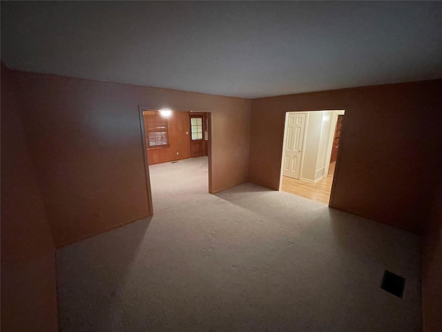 spare room featuring light carpet