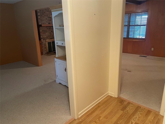 hallway featuring wood walls and light wood-type flooring