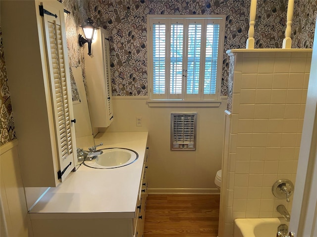 bathroom featuring vanity, hardwood / wood-style flooring, toilet, and heating unit