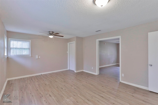 unfurnished room with light hardwood / wood-style flooring, a textured ceiling, and ceiling fan