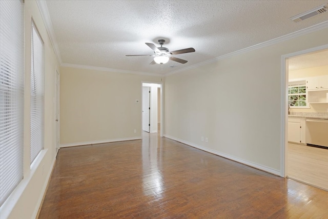 spare room featuring crown molding, a textured ceiling, and wood-type flooring