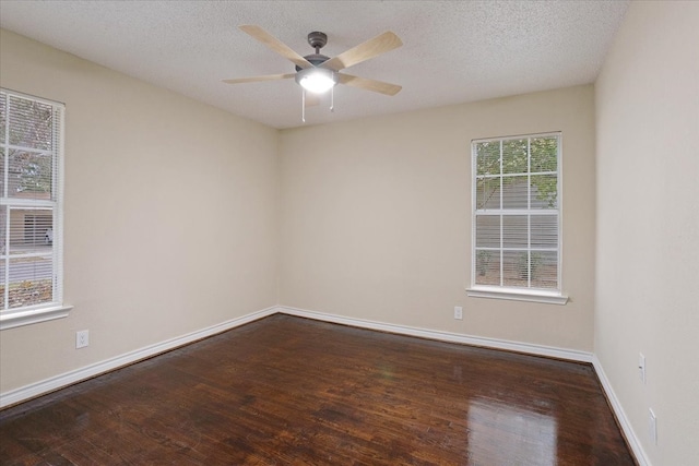 unfurnished room with a textured ceiling, dark wood-type flooring, and ceiling fan