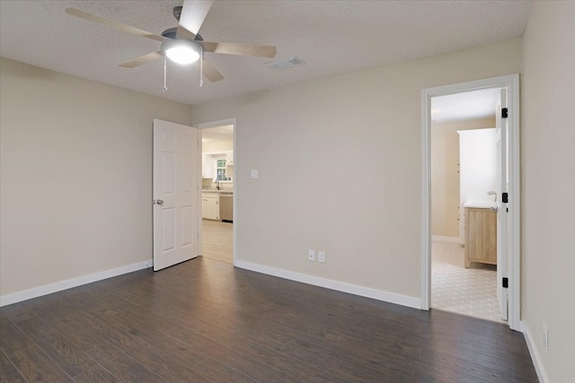 unfurnished room with dark hardwood / wood-style floors, a textured ceiling, and ceiling fan