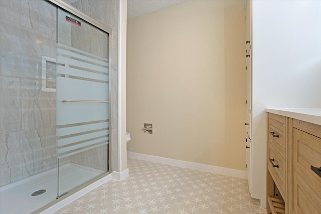 bathroom featuring vanity, toilet, walk in shower, and a textured ceiling