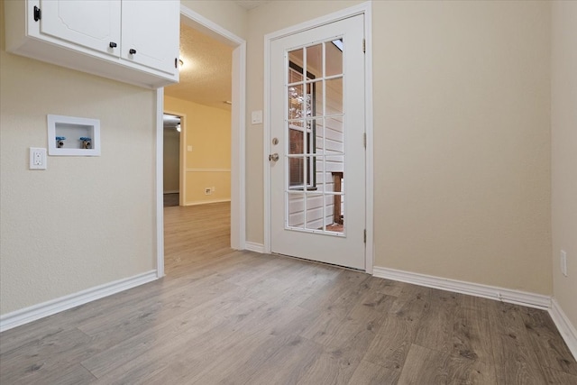 interior space with a textured ceiling and light hardwood / wood-style floors