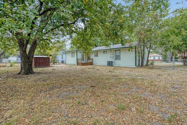 back of house featuring central AC and a shed