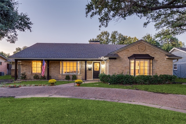 ranch-style home with a lawn and central air condition unit