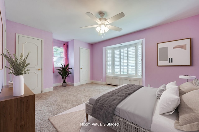 carpeted bedroom featuring multiple windows and ceiling fan