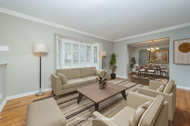 living room with a chandelier, light hardwood / wood-style flooring, and ornamental molding