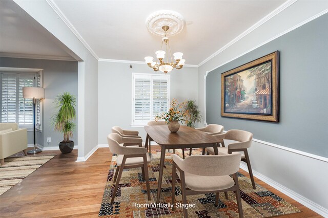 dining space with light hardwood / wood-style flooring, a chandelier, and ornamental molding