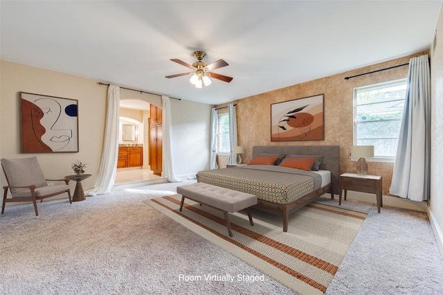 carpeted bedroom featuring ensuite bath and ceiling fan