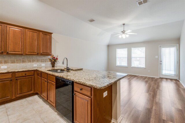 kitchen featuring lofted ceiling, sink, black appliances, light tile patterned flooring, and kitchen peninsula