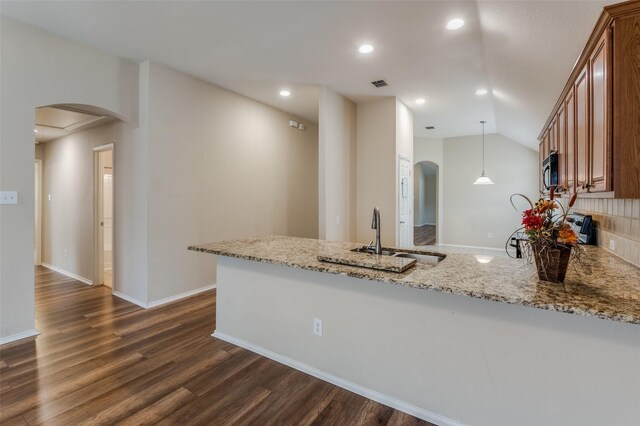 kitchen featuring sink, light stone counters, black dishwasher, kitchen peninsula, and decorative backsplash