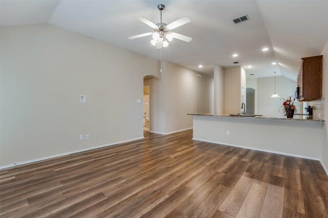 unfurnished living room featuring vaulted ceiling, ceiling fan, and light hardwood / wood-style floors