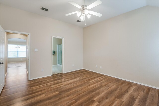 empty room with ceiling fan, wood-type flooring, and vaulted ceiling