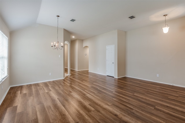 empty room with lofted ceiling, wood-type flooring, and a chandelier