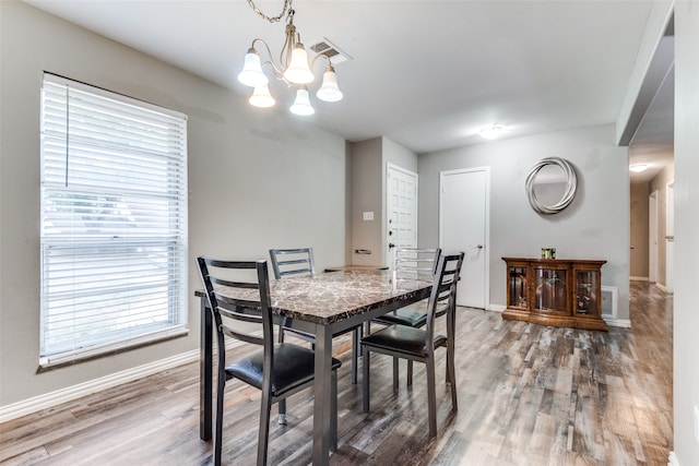 dining space featuring hardwood / wood-style floors and a notable chandelier