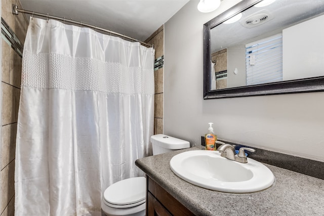 bathroom with vanity, toilet, and walk in shower