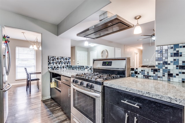 kitchen with tasteful backsplash, appliances with stainless steel finishes, dark wood-type flooring, decorative light fixtures, and ventilation hood