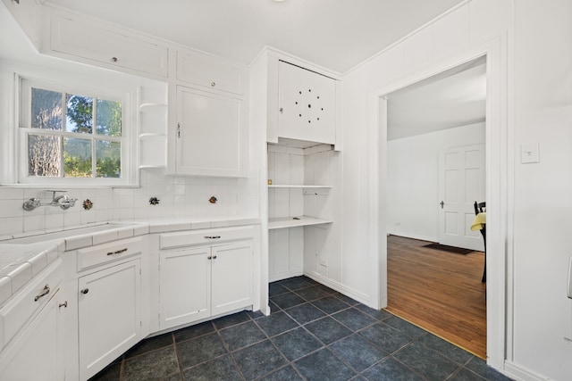 kitchen featuring sink, white cabinetry, tile counters, dark wood-type flooring, and decorative backsplash