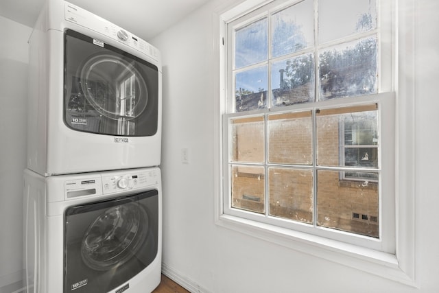 laundry room featuring a healthy amount of sunlight and stacked washer and dryer