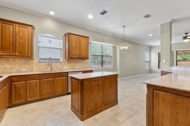 kitchen featuring tasteful backsplash, stainless steel dishwasher, ceiling fan with notable chandelier, sink, and a center island