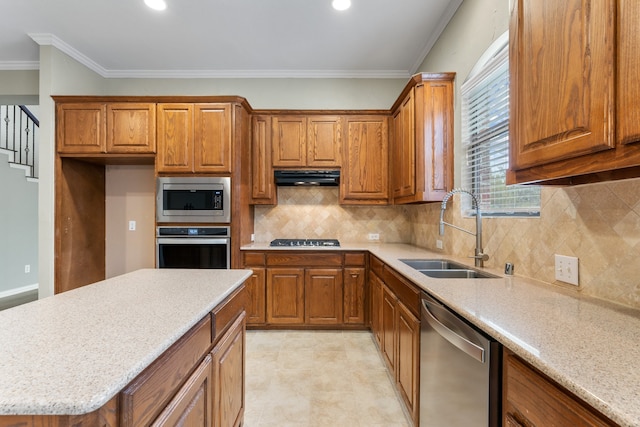 kitchen with light stone countertops, backsplash, stainless steel appliances, crown molding, and sink