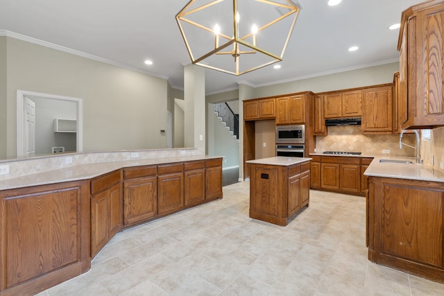 kitchen featuring a center island, sink, stainless steel appliances, decorative light fixtures, and ornamental molding