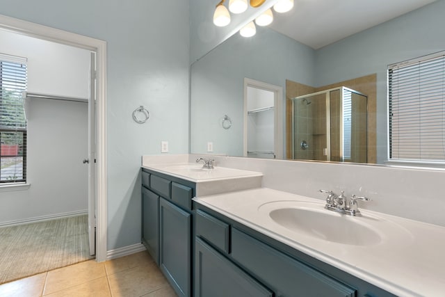 bathroom featuring tile patterned flooring, vanity, and a shower with door