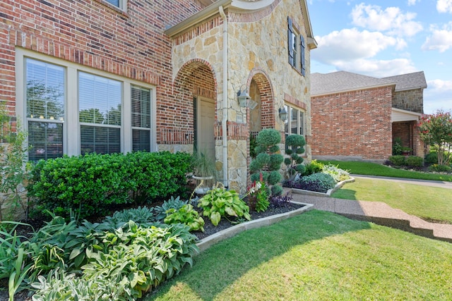 property entrance featuring a lawn