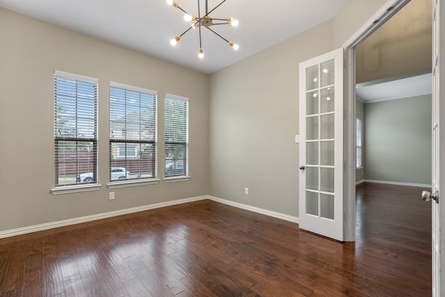 spare room featuring french doors, dark hardwood / wood-style flooring, and a notable chandelier