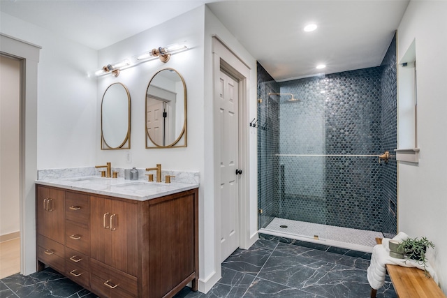 bathroom with double vanity, marble finish floor, walk in shower, and a sink