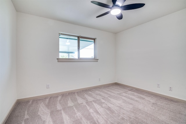 unfurnished room with baseboards, a ceiling fan, and light colored carpet