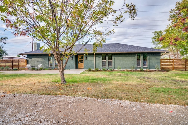 ranch-style home featuring a front yard, fence, a patio, and brick siding