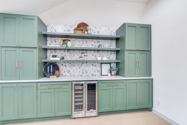 bar featuring beverage cooler and green cabinetry